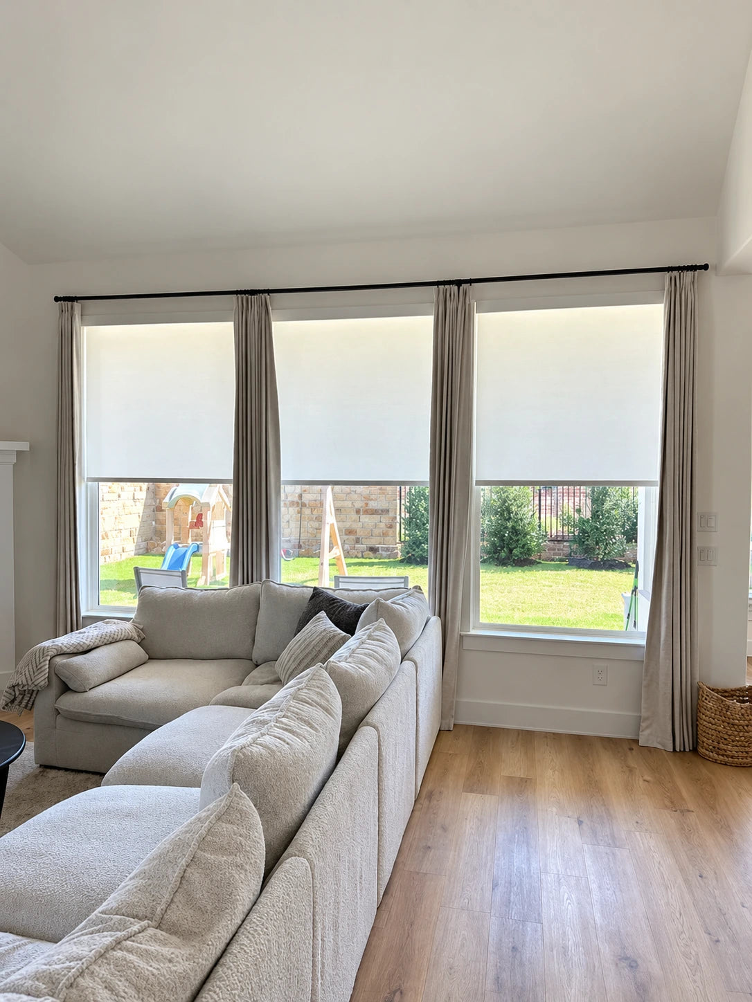 Completed BLINDS100 shades across a bank of living room windows